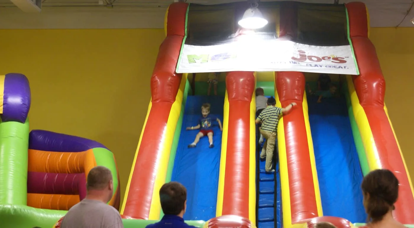 kid on a inflatable slide at Monkey Joe's indoor bounce house