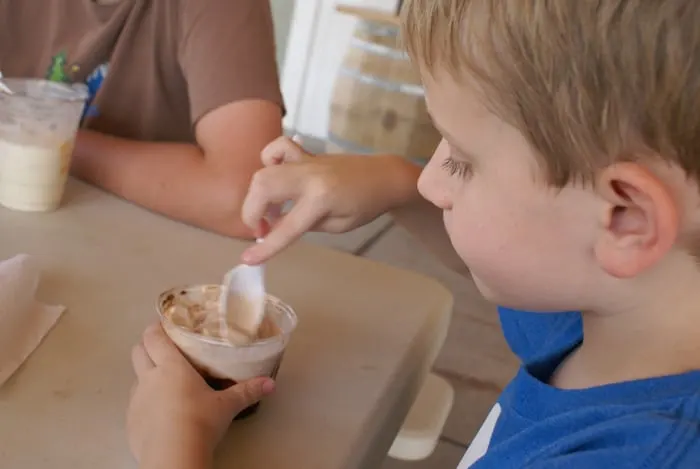 kid eats ice cream in a cup