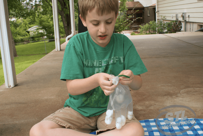 kid in green shirt holding clear glove