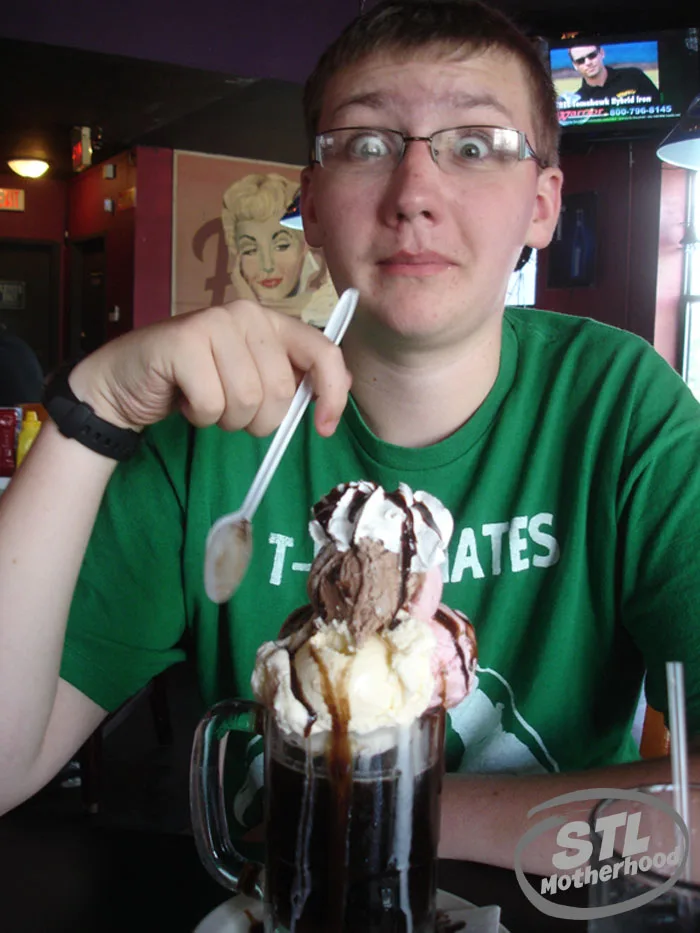 teen having a 3 scoop Fitzs Root Beer ice cream float, his eyes are huge looking at the size of the float