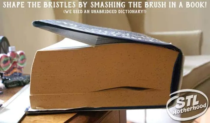 shaping the bristles of a brush bot by smashing it in a large book