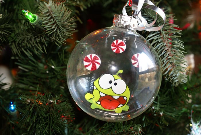 photo of Om Nom, cut out, floating in a glass Christmas ornament with peppermint candies