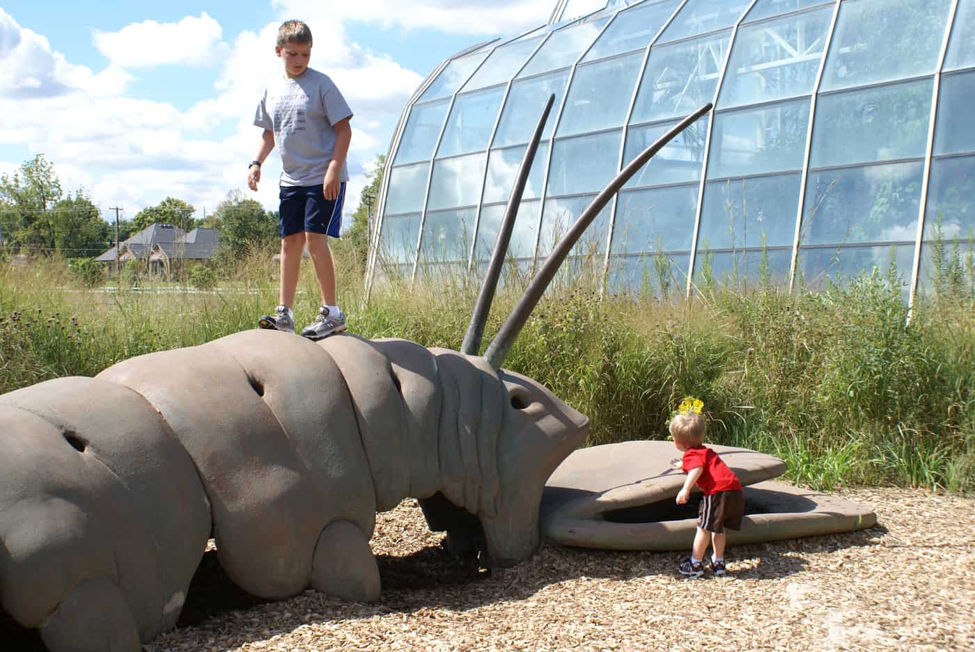 kids playing on caterpillar sculpture at the Butterfly House