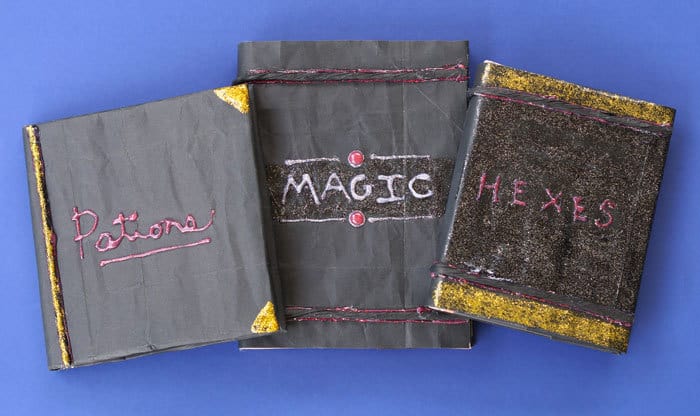 3 Halloween spell books made from black paper and glitter glue