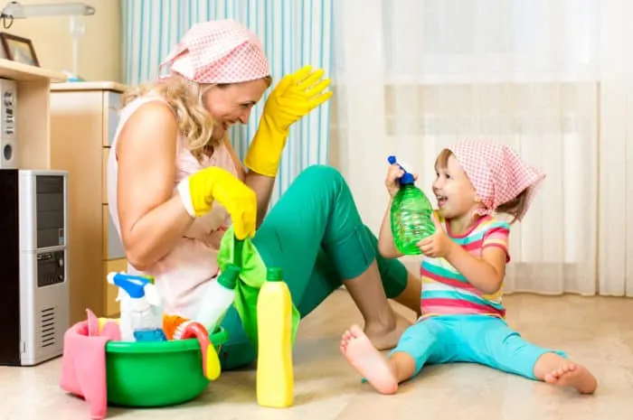 happy mother with kid cleaning room and having fun