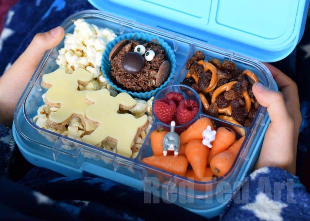 Bento box holding snacks with dog shapes cut with cookie cutters.