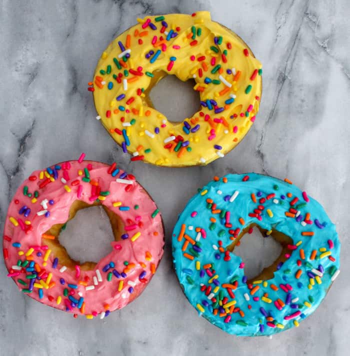 colorful donuts that are really apple rings with colored cream cheese & sprinkles