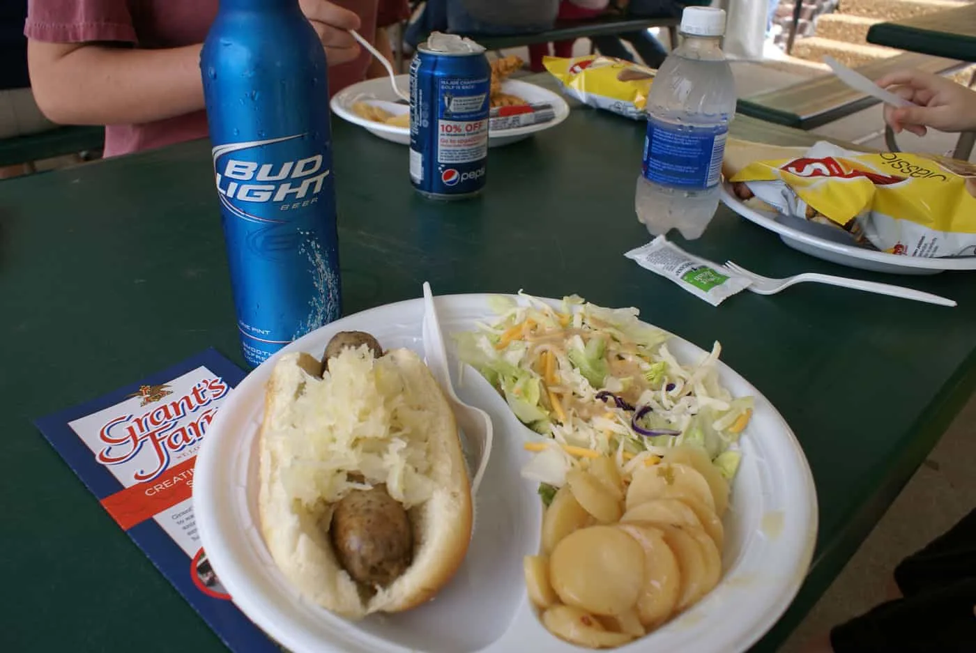 Lunch at Grant's Farm: brat on bun with sauerkraut, potato salad and green salad on paper plate with Bud Light.  