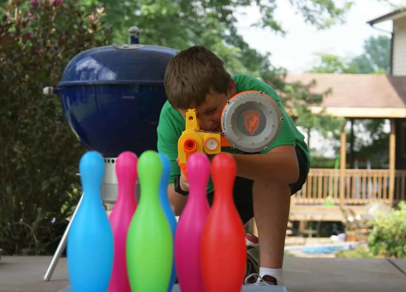 boy playing with Nerf and bowling pins