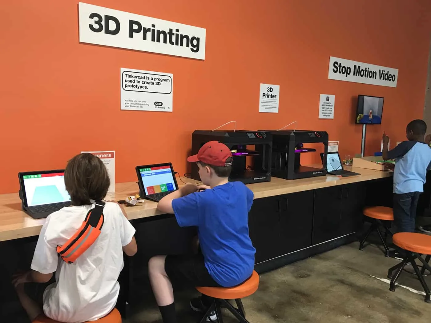 kids working on computers by the 3D printer
