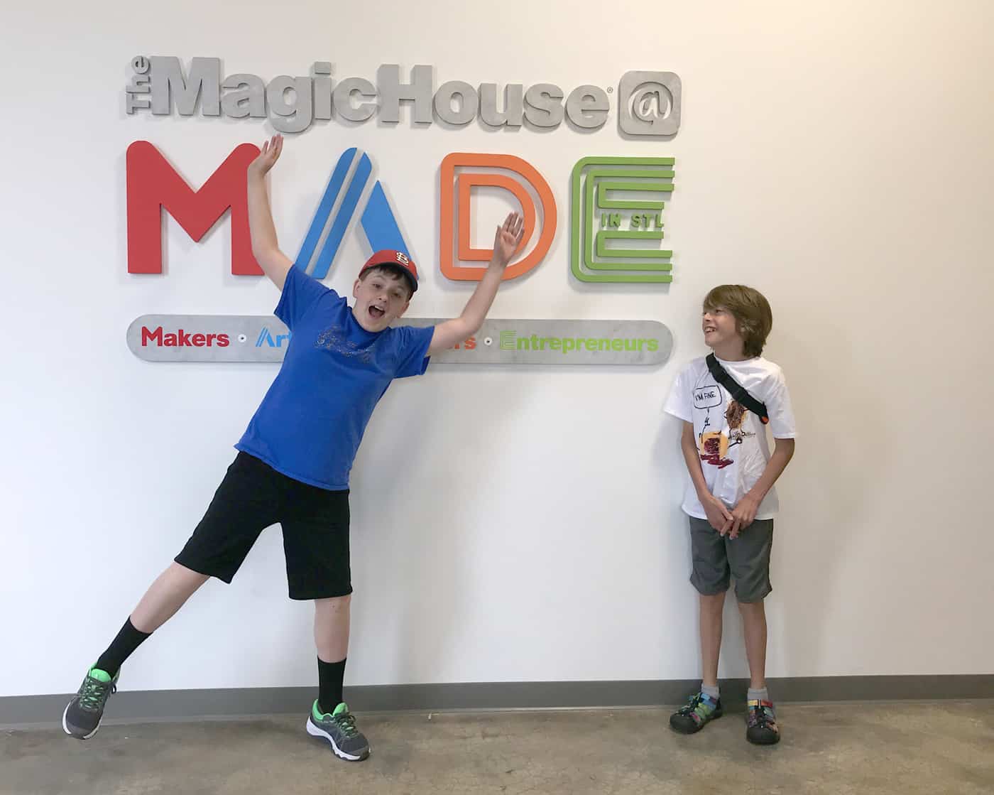 two boys in front of the MADE sign.