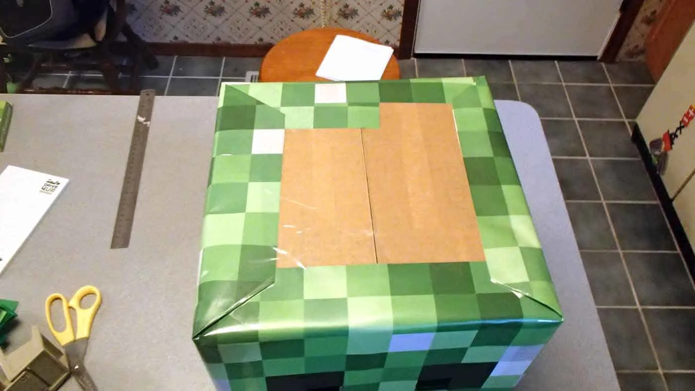 creeper costume head printed on paper, wrapping it around a box