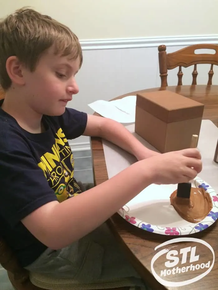 kid painting a box