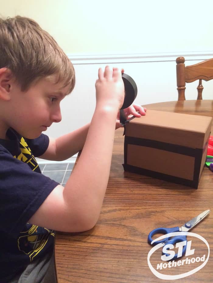 kid taping a box to look like a Minecraft chest