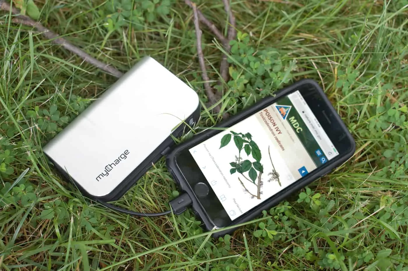 iphone on grass, plugged into a myCharge power bank