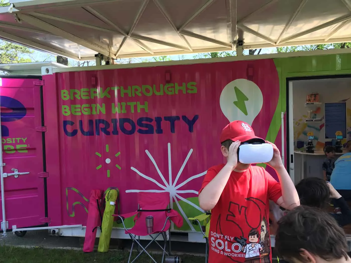 kid uses virtual reality goggles to check out microbes  at the Curiosity Cube tour