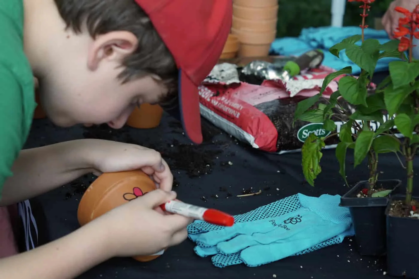 kid decorating a clay pot