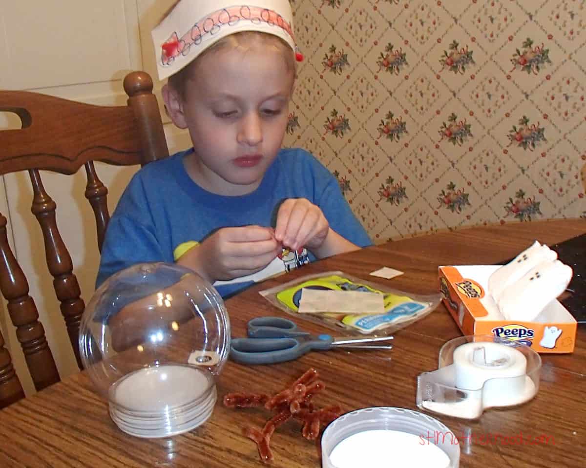 kid crafting for halloween while wearing silly hat