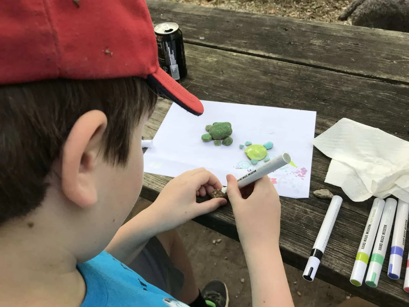 kid using a paint pen on rocks