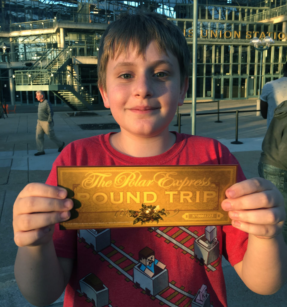 Boy in red shirt with golden Polar Express Ticket in St. Louis Union Station