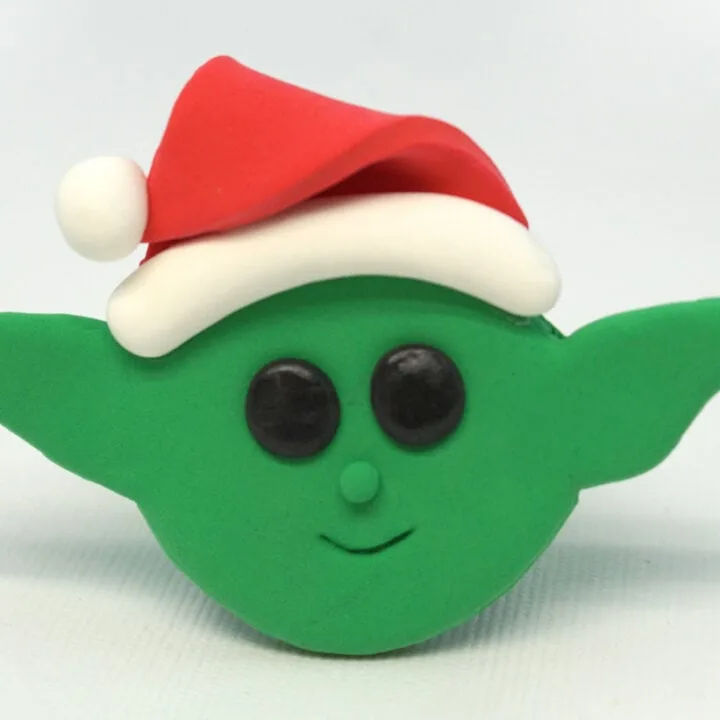 Baby Yoda Christmas Ornament made from green Model Magic and wearing a red Santa hat.