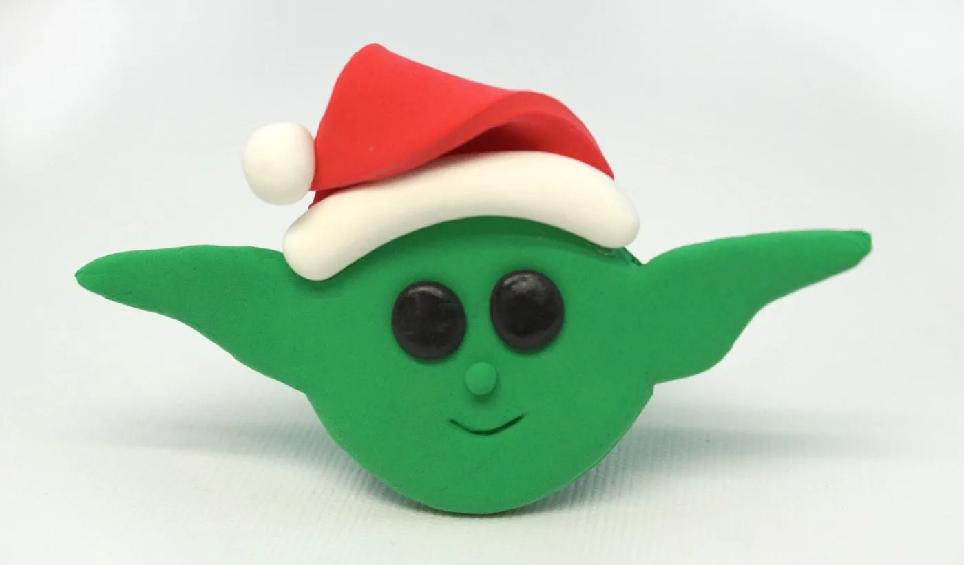 Baby Yoda Christmas Ornament made from green Model Magic and wearing a red Santa hat.