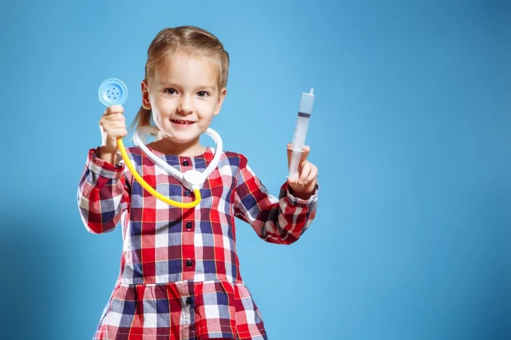 kid in plaid dress pretending to be a doctor 