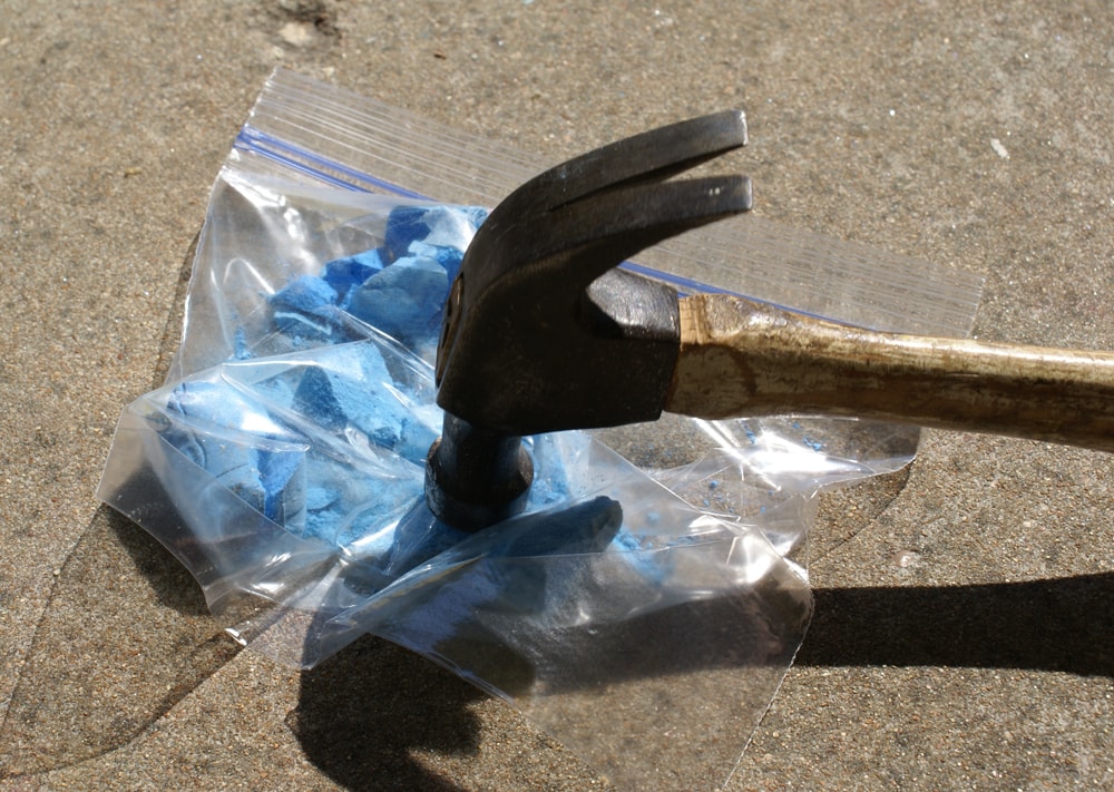 hammer crushing bag of sidewalk chalk into powder