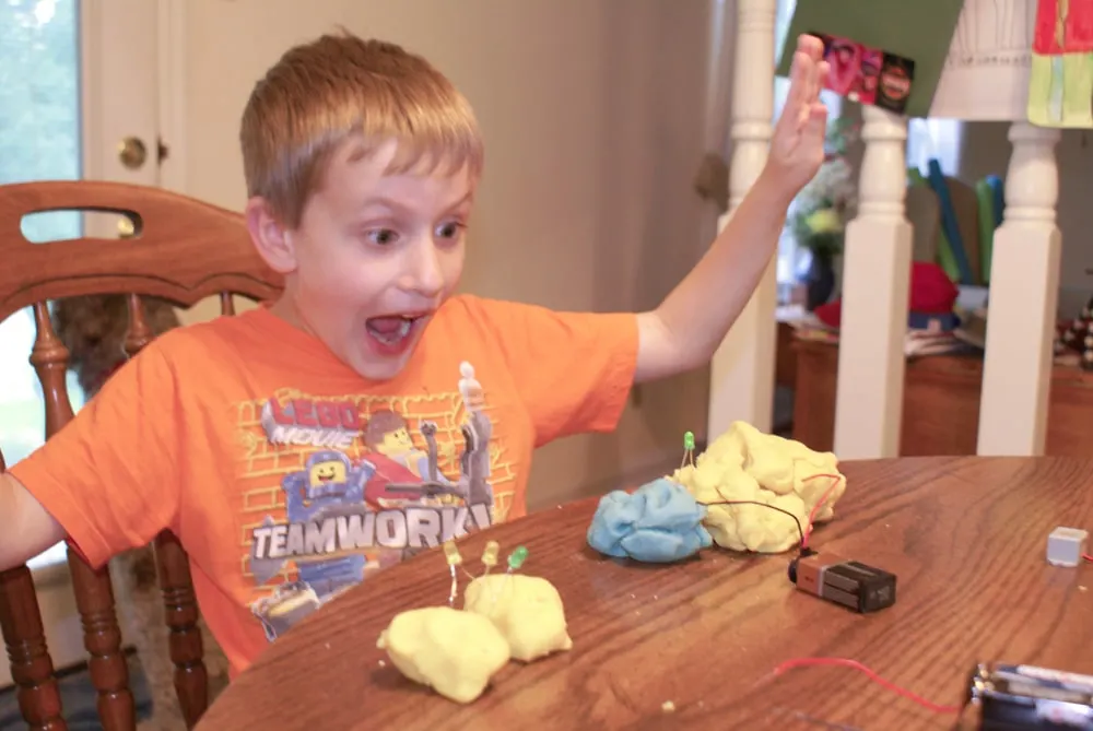 boy excited about electric playdough experiment with an LED light