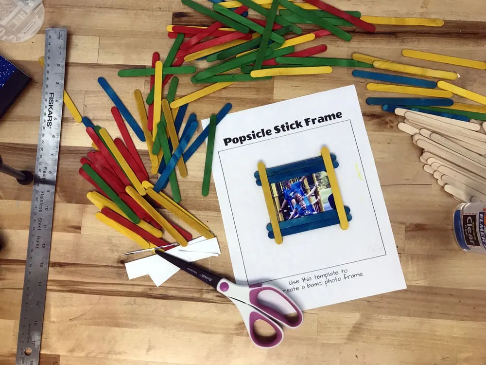 finished craft stick photo frame surrounded by colorful Popsicle sticks