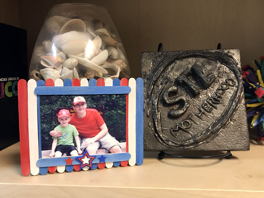 Red, white and blue craft stick photo frame on display on a shelf.