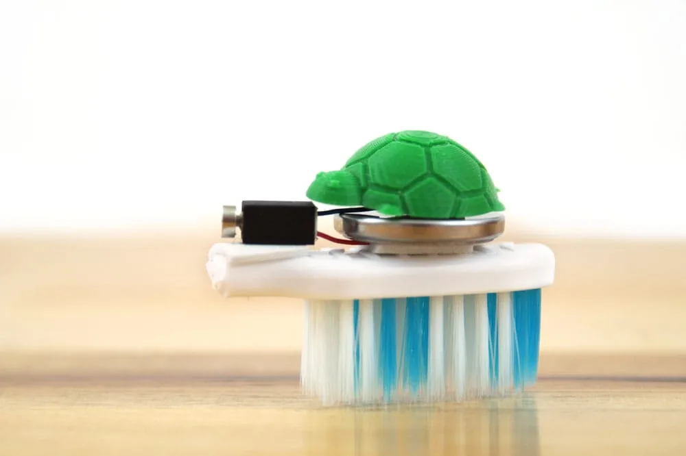 green plastic turtle on a brush bot made from a toothbrush