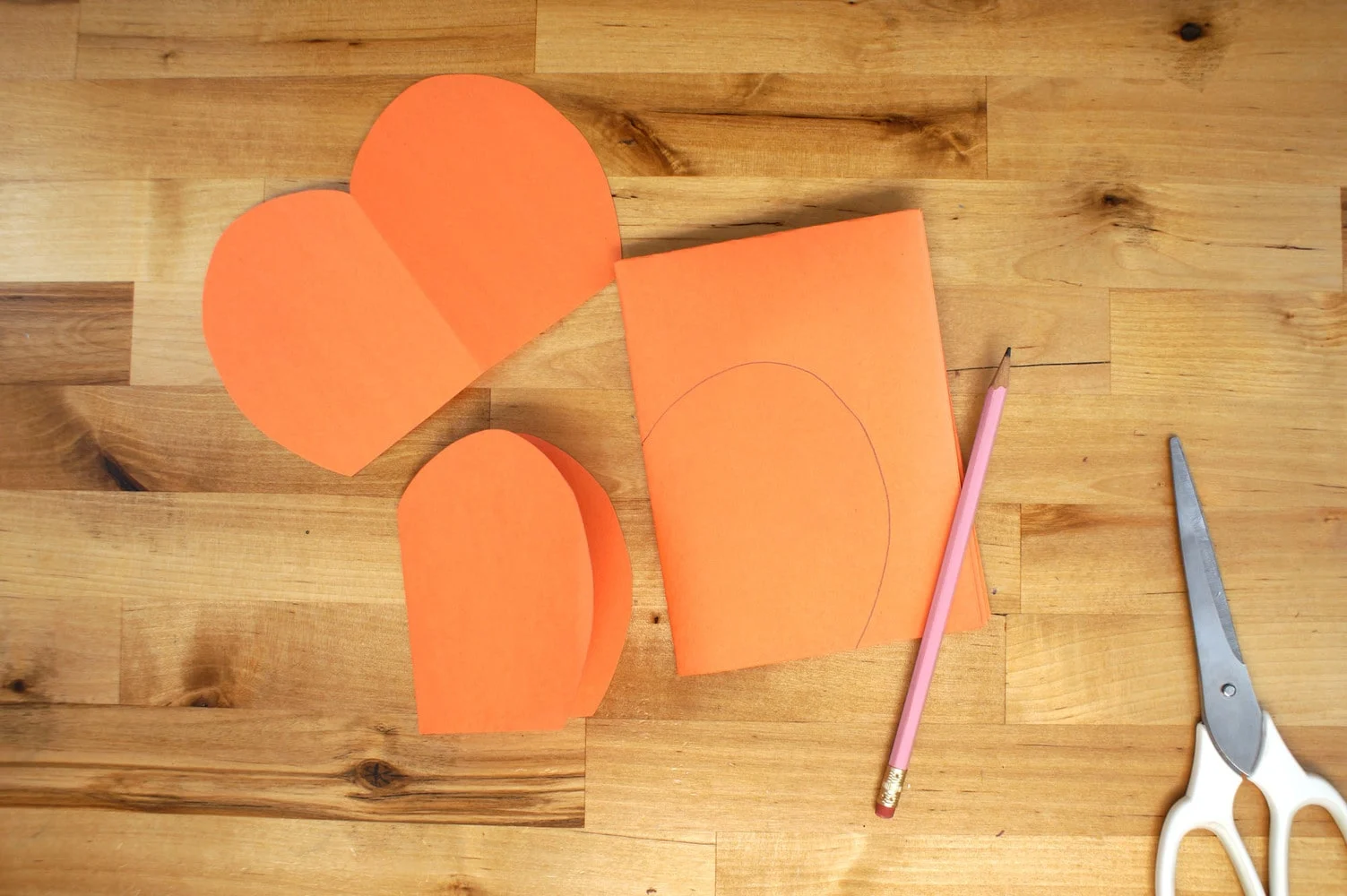 How to make a 3D pumpkin with sheets of orange paper, pencil and scissors