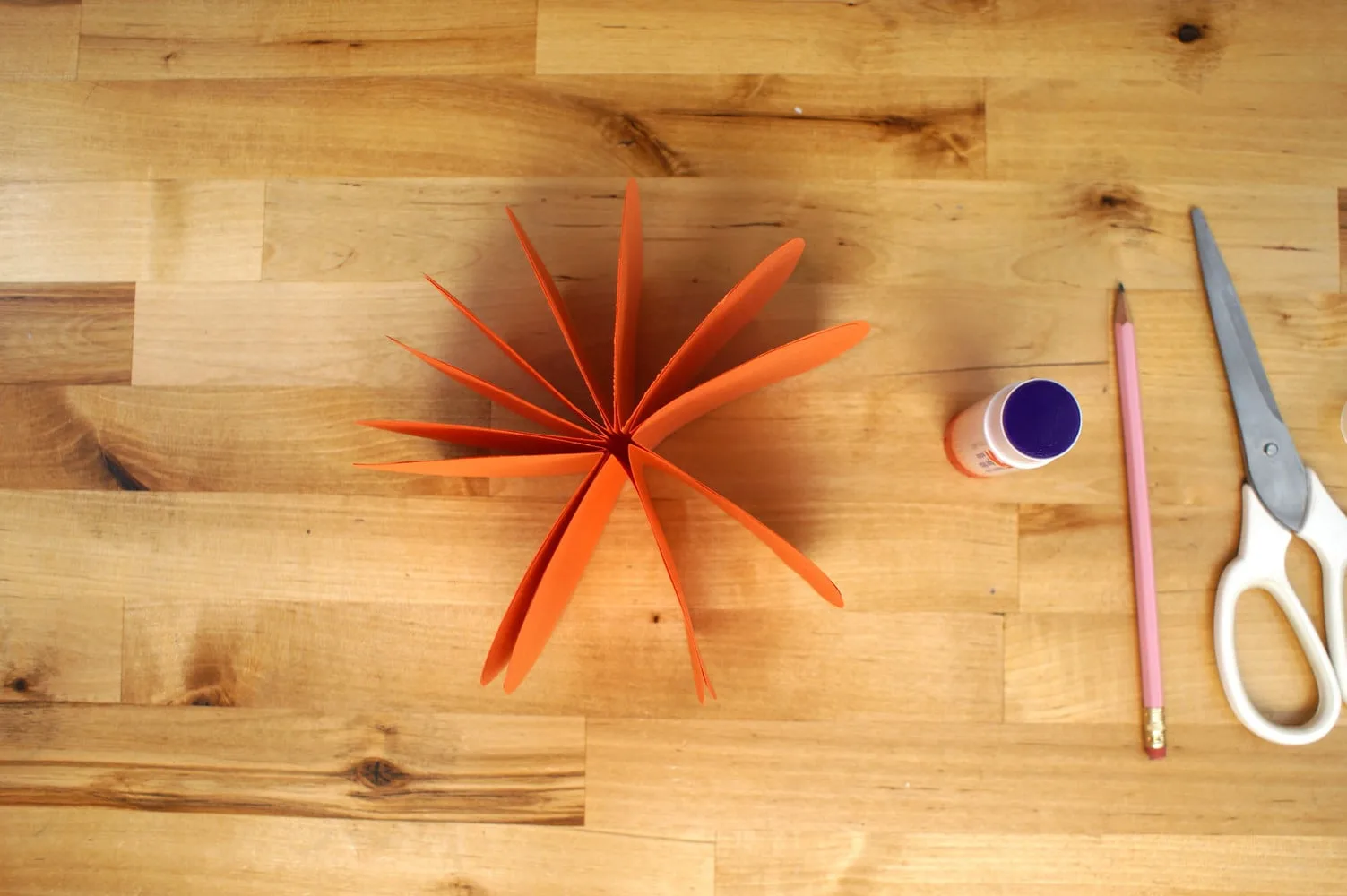 Gluing all the pumpkin slices together to form a circle.