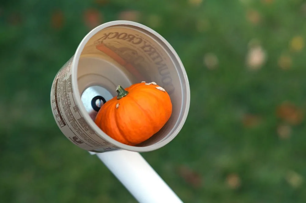 small pumpkin in a pvc catapult basket made from a butter tub