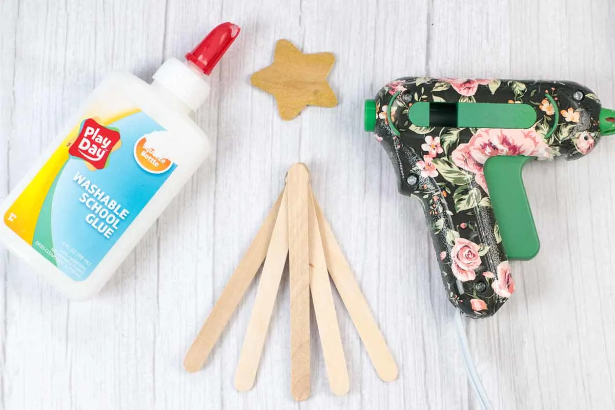 making a popsicle stick and pom pom Christmas tree