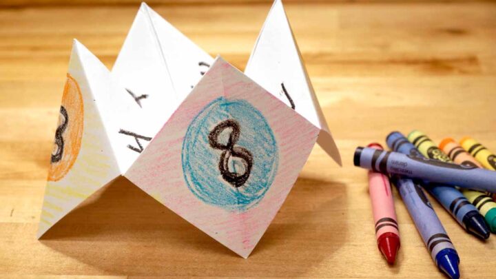 paper fortune teller next to crayons