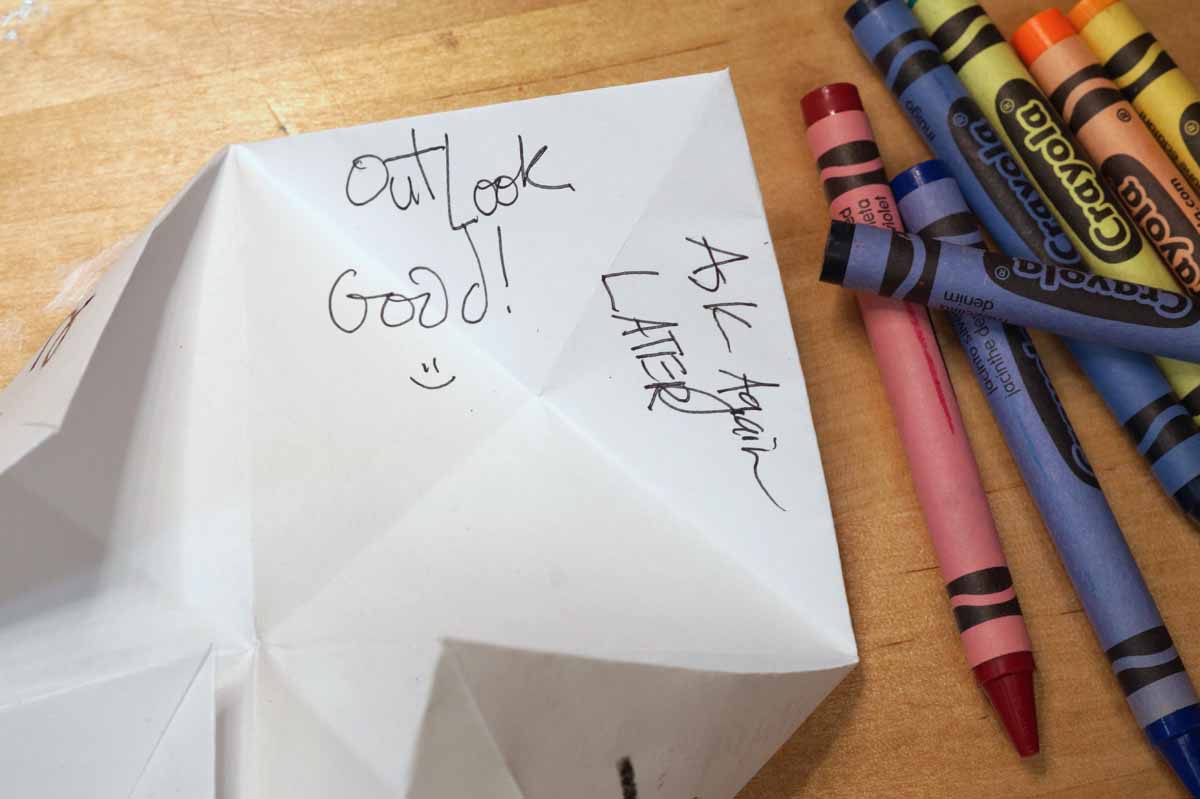 magic 8 ball fortunes inside a paper fortune teller: this one says "outlook good!" and "ask again later"