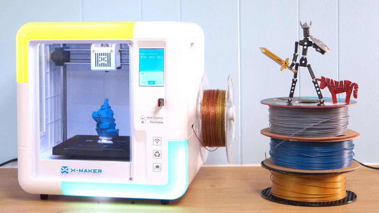 AoSeed XMaker 3D printer with a stack of filament and toys that it printed