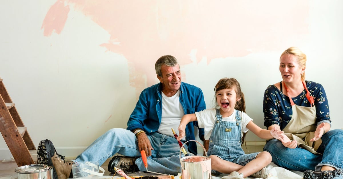 A family enjoys painting a room together, turning a home improvement project into a fun, creative bonding activity.